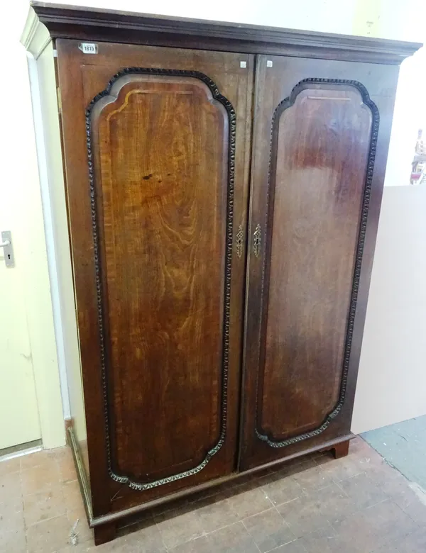 A George III mahogany knock-down wardrobe, with pair of arched panel doors on bracket feet, 127cm wide x 178cm high. Illustrated