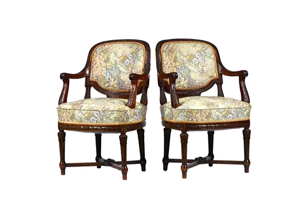 A pair of Louis XVI style open armchairs, circa 1900, with carved mahogany frames and bow seats, on spiral fluted supports, 58cm wide x 92cm high, (2)