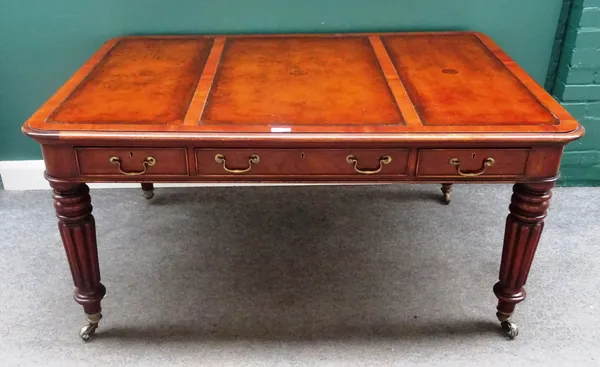 An early 19th century style mahogany centre writing table, with three frieze drawers and dummy opposing, on tapering reeded supports, 152cm wide x 102