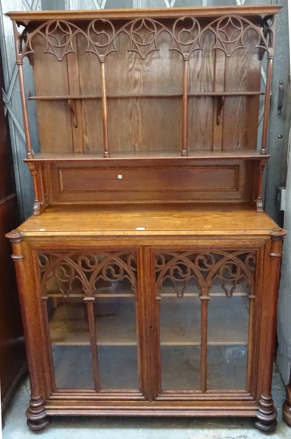 A 19th century oak Gothic Revival side cabinet, the ledge back over pair of glazed doors flanked by turned columns, 120cm wide x 188cm high x 50cm dee
