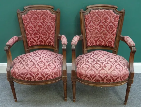 A pair of Louis XVI style walnut framed open armchairs, each with bow seat on tapering fluted supports, 56cm wide x 89cm high, (2).
