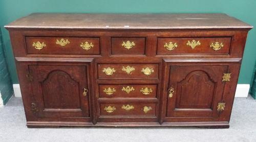 An 18th century oak dresser base, with six drawers flanked by cupboards, 178cm wide x 88cm high x 48cm deep.