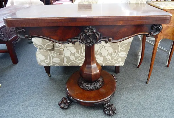A Regency rosewood card table, the fold out 'D' shaped top on an octagonal baluster column and four lion's paw feet, 92cm wide x 74cm high x 45cm deep