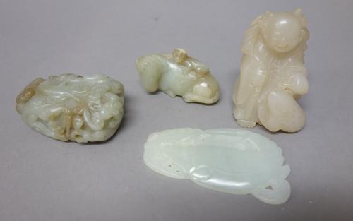 A group of four Chinese jade carvings, 19th/20th century, of various tones, comprising; a group of a recumbent horse and monkey, 4.5cm. length; a man