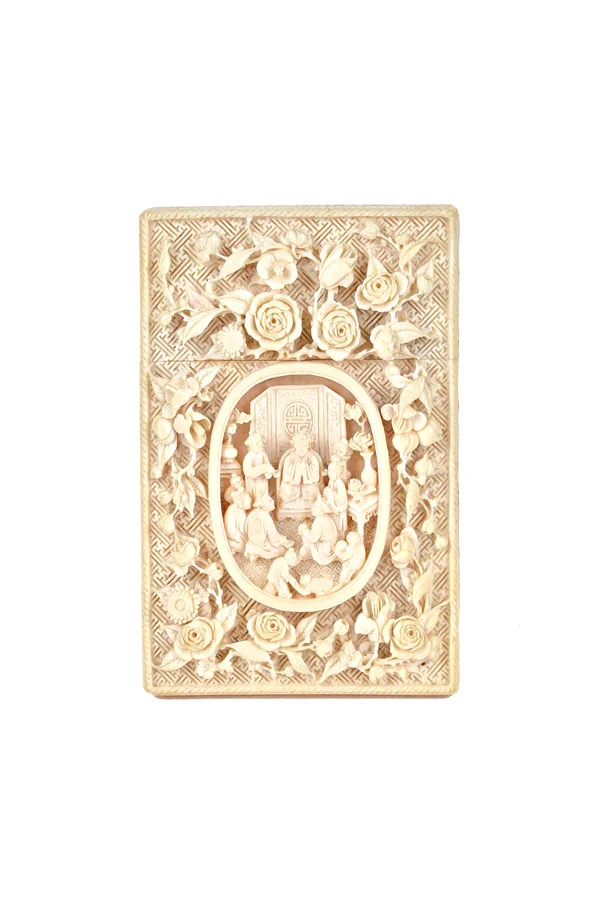 A Canton ivory rectangular card case, late 19th century, carved on one side with an oval panel enclosing a seated dignitary and attendants, framed by