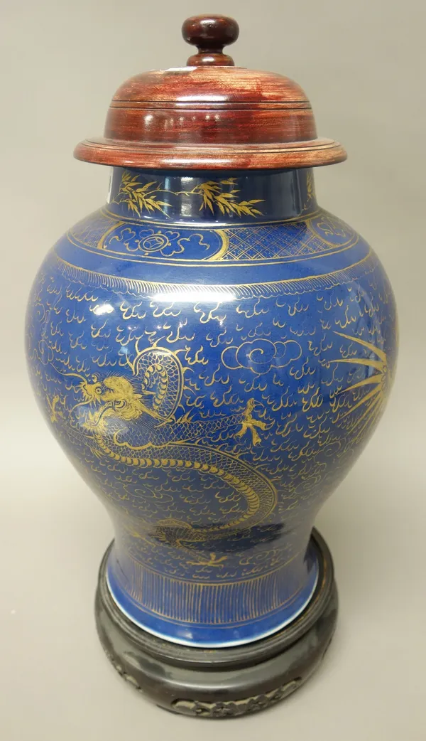 A Chinese blue ground baluster vase, gilt with dragons and phoenix amongst cloud scrolls, 35cm. high, wood cover and stand, (3).