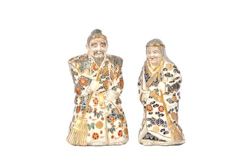 A pair of Japanese Satsuma figures of an elderly man and a woman, second half 19th century, each modelled standing in long robes with a broom,  the wo