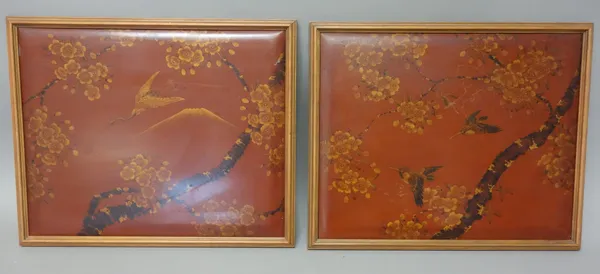 A pair of Japanese rectangular red lacquer panels, 20th century, each painted with birds flying amongst blossoming branches, 31cm. by 39cm., framed (2