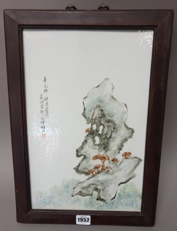 A Chinese porcelain rectangular plaque, painted with fungus and greyish blue rocks beside calligraphy, 37cm. by 24cm., framed.