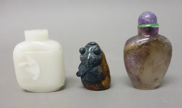 A Chinese amethyst quartz snuff bottle, late 19th/20th century, carved with lotus flowers, 5.5cm. high; also a pebble snuff bottle, probably crocidoli