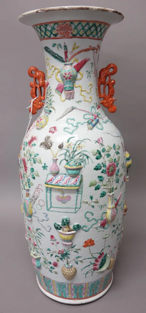 A large Chinese famille-rose two-handled baluster vase, late 19th/20th century, moulded in high relief with vases of flowers, insects, fruit and Buddh