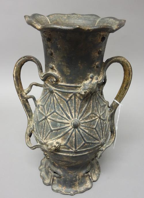 An Asian bronze two-handled baluster vase, perhaps Japanese, with petal rim and foot, the body decorated in relief with a band of star designs, set wi