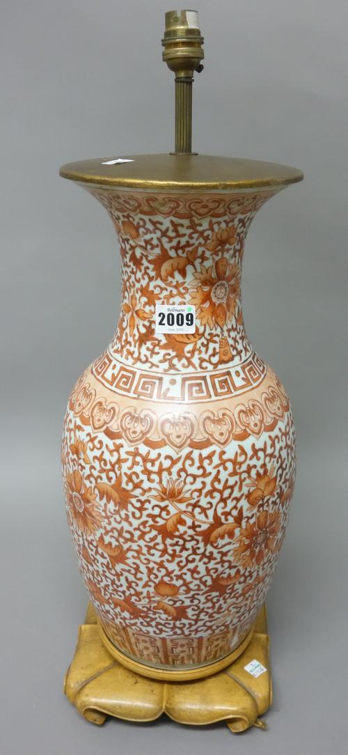 A Chinese porcelain baluster vase, late 19th/early 20th century, painted in painted in iron-red with lotus flowers, tendrils and fruit between ruyi he