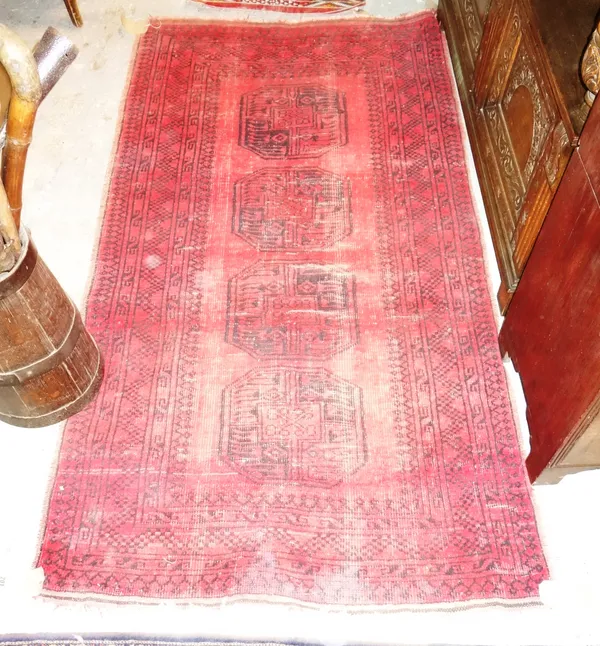 An Afghan rug with four bold medallions, 190cm x 103cm, a red Pakistan Bokhara 207cm x 127cm and a Moroccan flat weave runner, 228cm x 54cm. (3)   H6