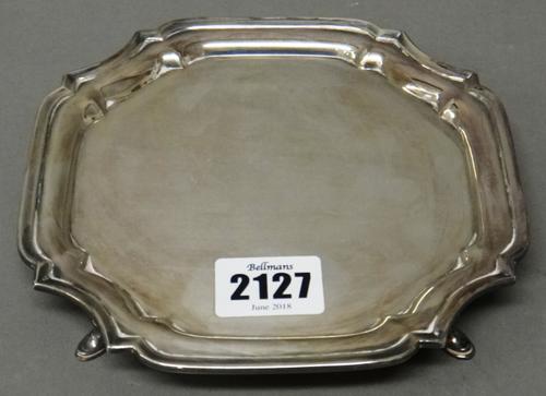 A silver waiter, of shaped circular form, in the early 18th century taste, raised on four feet, diameter 15cm, weight 168 gms.