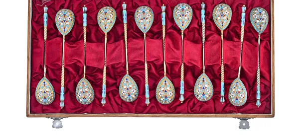 A set of twelve Russian gilt and cloisonne enamelled teaspoons, each with enamelled decoration to the back of the fig shaped bowl, the stem with spira