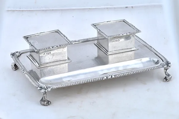 A silver shaped rectangular twin bottle inkstand, with two square hinged ink bottle stands, with glass ink bottle liners, with a pen recess and raised