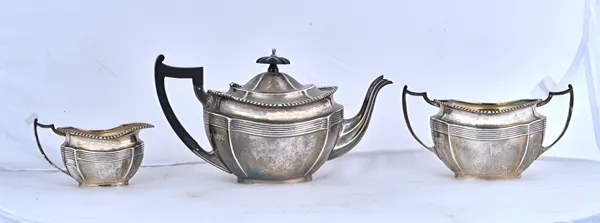 A silver three piece tea set, comprising; a teapot, a twin handled sugar bowl and a milk jug, each piece of shaped oval form, decorated with a fluted