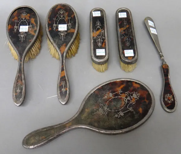 A lady's silver mounted tortoiseshell part dressing set, comprising; a hand mirror, a pair of hairbrushes and a pair of clothes brushes, each piece wi