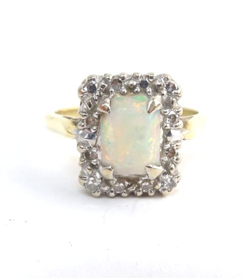 A gold, opal and diamond rectangular cluster ring, claw set with the opal at the centre, within a surround of circular cut diamonds, ring size M and a