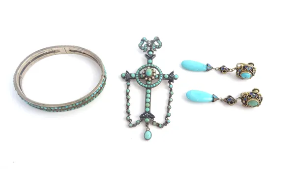 A turquoise and seed pearl set and black and white enamelled pendant cross, having a ribbon tied bow surmount and with pendant turquoise chains, a tur