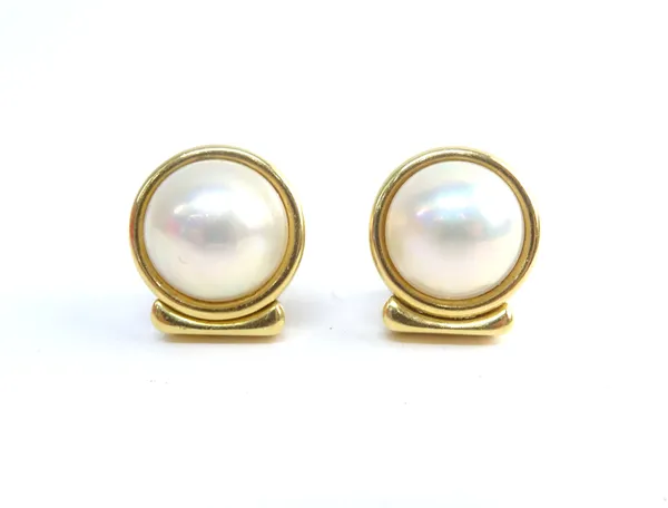 A pair of gold and mabe pearl earclips, in un-decorated circular settings, detailed to one earclip fitting 750, gross combined weight 26.5 gms.