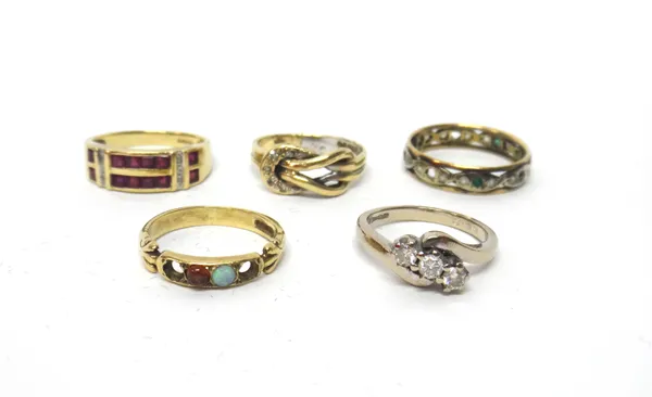 A 9ct gold, ruby and diamond set ring, in a two row design, an 18ct white gold and diamond set three stone ring, in a crossover design, a gold and dia