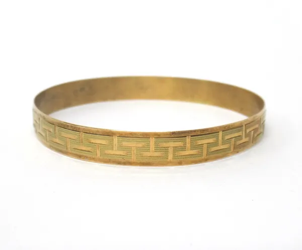 A gold circular bangle, decorated with an engine turned Greek key pattern design, detailed indistinctly 14, internal diameter 6.8cm, weight 15 gms.