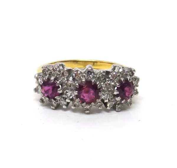 A gold, ruby and diamond set ring, in a triple cluster design, claw set with three circular cut rubies, surrounded by circular cut diamonds, ring size