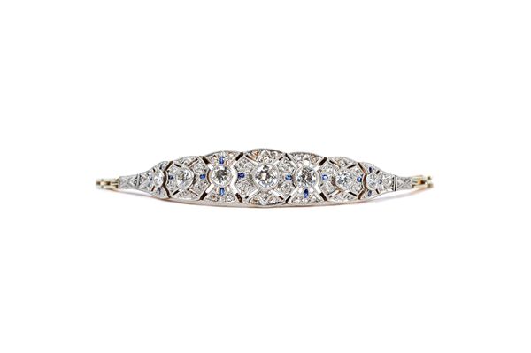 A gold, diamond and synthetic sapphire bracelet, the front in a tapered design, collet set with a row of the seven principal circular cut diamonds to