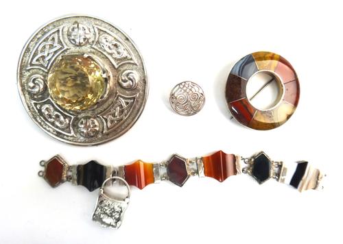 A Scottish silver and citrine set plaid brooch, of circular form, claw set with the circular cut citrine to the centre, within a cast border of Celtic