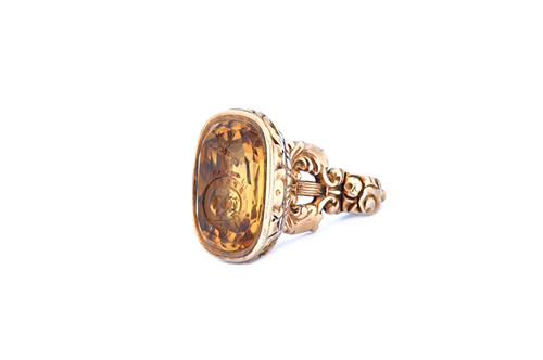 A Victorian gold cased citrine set pendant fob seal, the foil backed citrine base, seal engraved with a crest above a garter motto, otherwise with flo