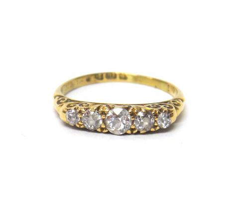 An 18ct gold and diamond set five stone ring, mounted with a row of cushion shaped diamonds, graduating in size to the centre stone, the mount decorat
