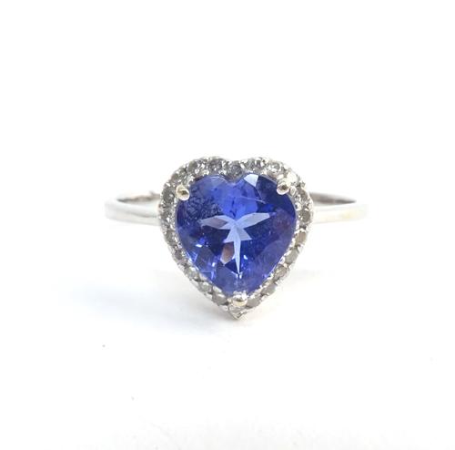 A tanzanite and diamond ring, claw set with a heart shaped tanzanite to the centre, within a heart shaped surround, set with circular cut diamonds, ri