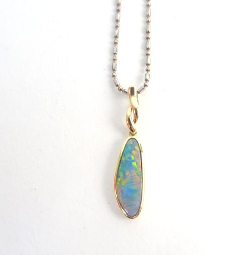 A gold and opal doublet set pendant, in a drop shaped design, detailed 14 K 585, with a base metal neckchain.