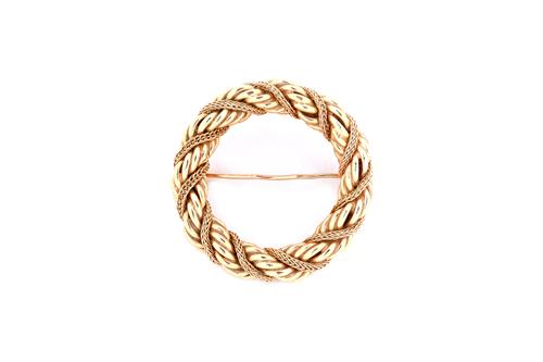 A gold brooch, of circular ropetwist and woven link openwork design, detailed indistinctly Tiffany 14 K, diameter 3.3cm, weight 13 gms. Illustrated