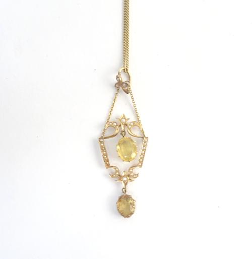 A gold, citrine and seed pearl pendant necklace, claw set with two oval cut citrines and otherwise set with seed pearls, in a pierced openwork design