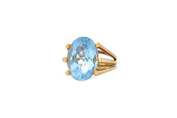 A gold and aquamarine single stone ring, claw set with an oval cut aquamarine in a wirework setting, with a triple band shank, detailed 18 K, ring siz