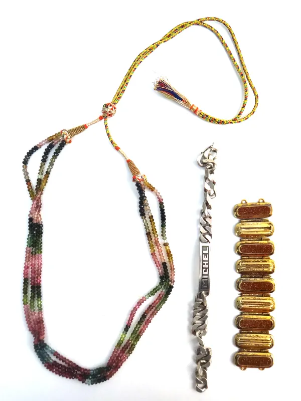 A three row necklace of varicoloured pink and green faceted tourmaline beads, a goldstone and gilt section of a bracelet and a faceted curb link ident