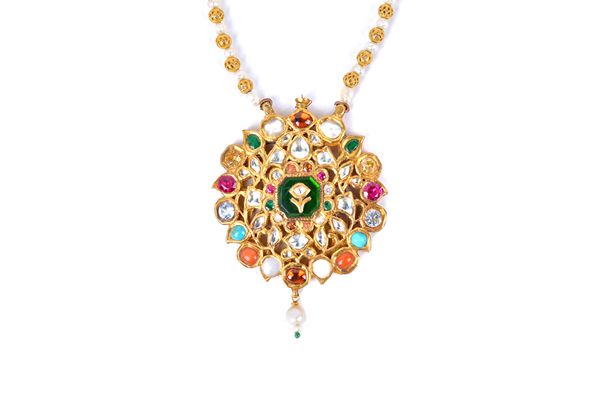 An Indian opal, coral, turquoise and varicoloured gem set pendant, in a shaped circular design evoking stylised leaves, on a filigree bead and culture