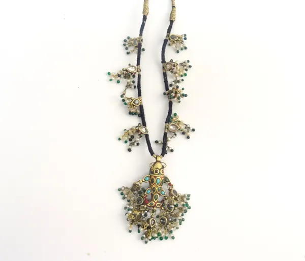 An Indian seed pearl, green glass bead and enamelled necklace, the central drop designed as a fish, suspending pear shaped drops hung with seed pearls