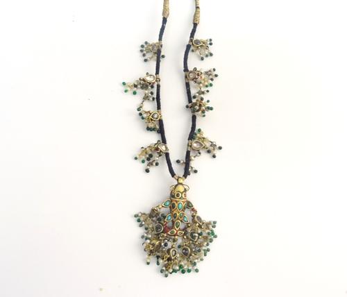 An Indian seed pearl, green glass bead and enamelled necklace, the central drop designed as a fish, suspending pear shaped drops hung with seed pearls