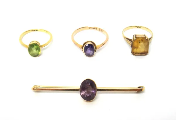 A gold and citrine single stone ring, detailed 9CT, a gold ring, collet set with an oval cut peridot, detailed 18CT, a gold and amethyst single stone
