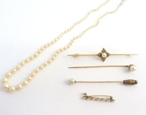 A gold and cultured pearl bar brooch, the centre with a quatrefoil shaped motif, centred by a cultured pearl, detailed K18, two cultured pearl stick p