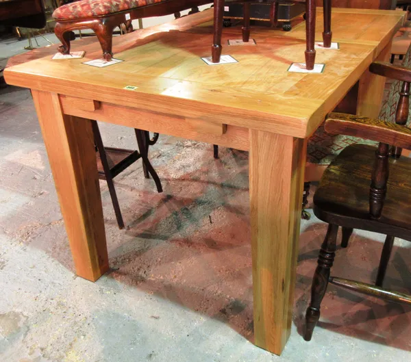 A 20th century oak extending dining table, on square tapering block supports, 140cm wide x 79cm high.  E7