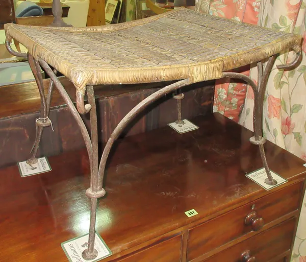 A 20th century wrought iron and wicker footstool, 61cm wide x 43cm high.  E6