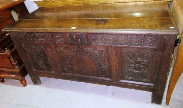 A James I style oak coffer with triple panel carved front, on block supports, incorporating period timber and elements, 136cm wide x 76cm high.  D5