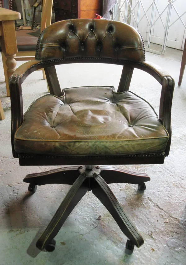 A 20th century mahogany framed button back leather upholstered office swivel open armchair.  C8