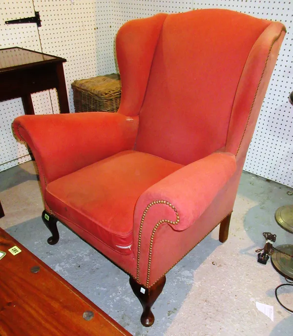 A George I style wingback armchair, on stained beech pad feet.  C6
