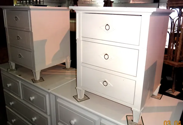 A pair of 20th century white painted bedside chests of three short drawers, 53cm wide x 63cm high, (2).  L7